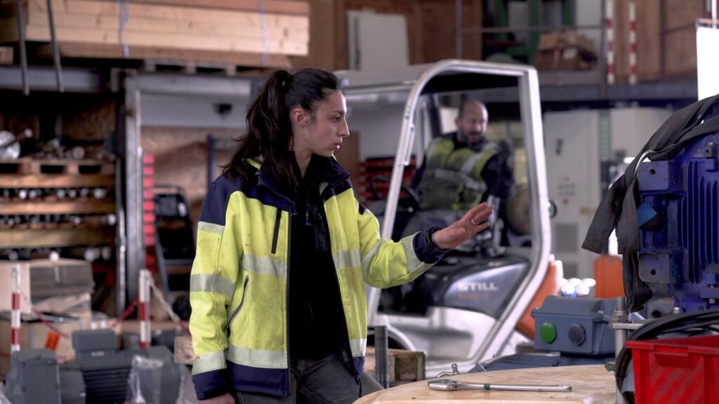 Technicienne en gilet haute visibilité dans l'atelier de maintenance
