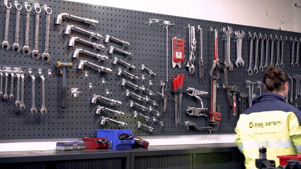 Mur d'outillage de l'atelier et technicienne ase-serem