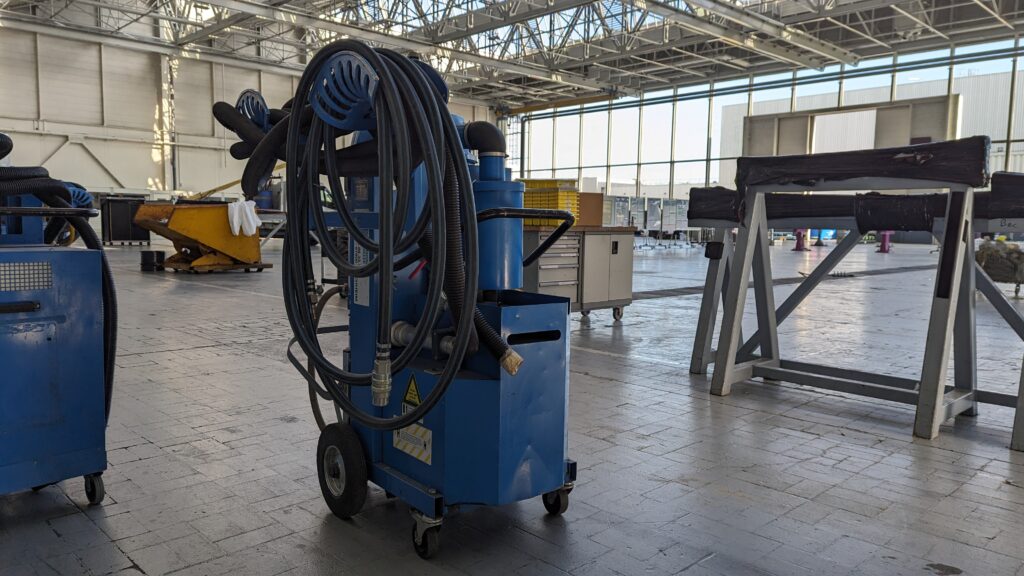 Aspirateur industriel en service dans un hangar aéronautique